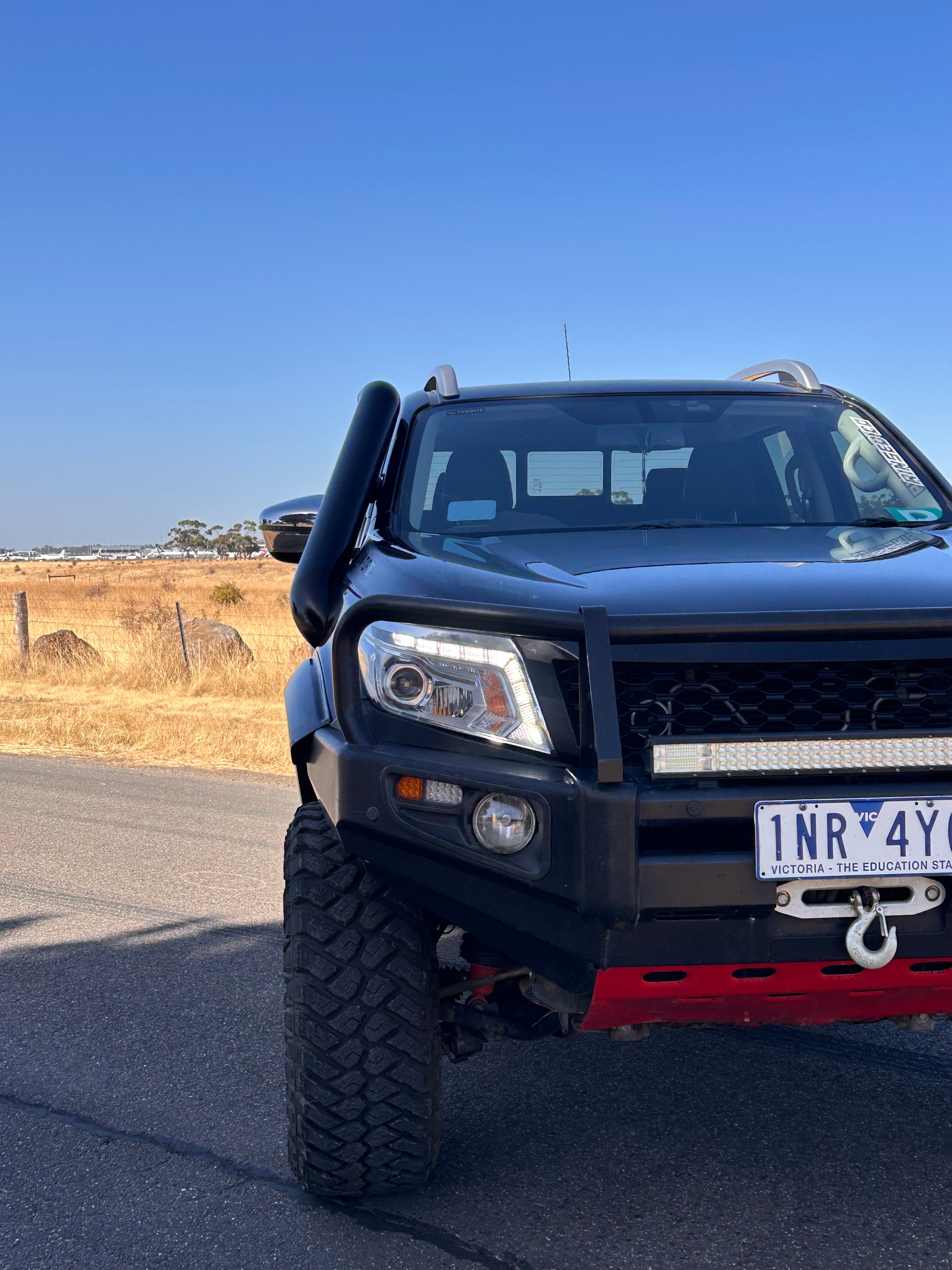 Black Nissan Navara NP300 front view with Canna Fabrication short-entry stainless snorkel fitted