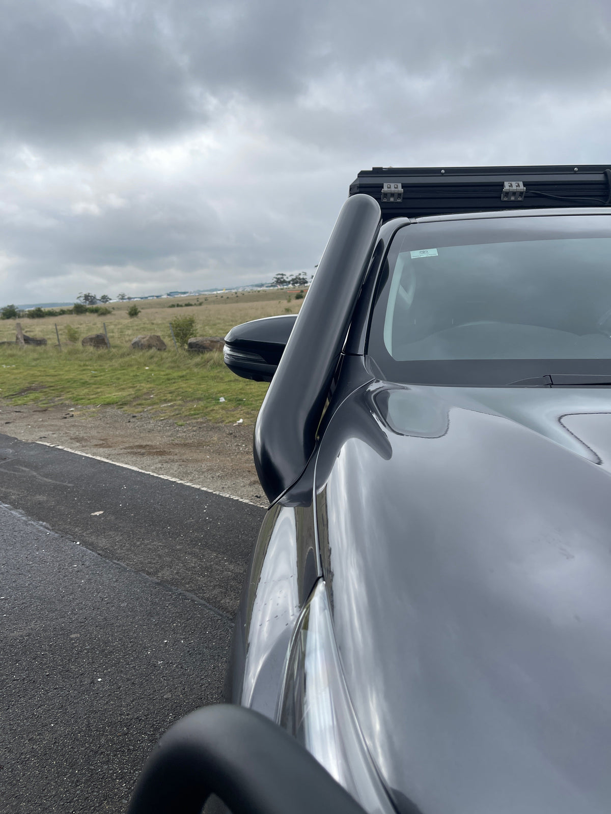 Close-up of the Canna Fabrication short-entry snorkel on a white Toyota Hilux N80