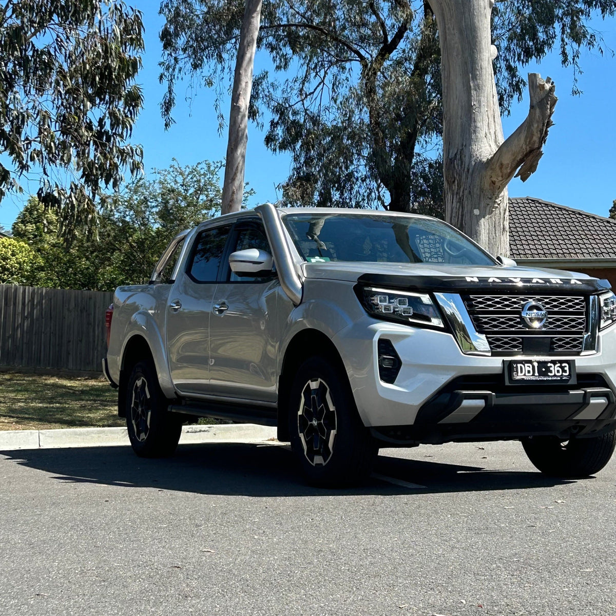 White Nissan Navara NP300 with sports bar and Canna Fabrication brushed-silver short-entry snorkel — front three-quarter view