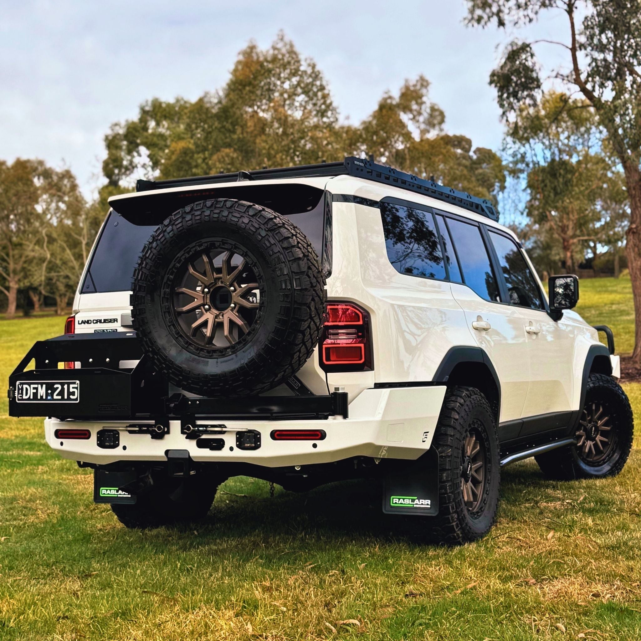 This is an image of the 250 Series Prado Toyota Landcruiser Rear Bar and Wheel Carrier setup by Raslarr Engineering Made in Australia White Black HERO photo blue red silver