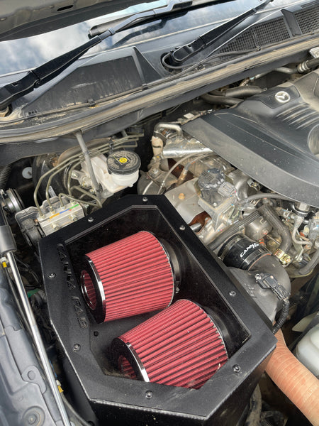 Canna Fabrication twin-pod filter aftermarket airbox with red pod filters — engine-bay install (BT-50 / D-Max)