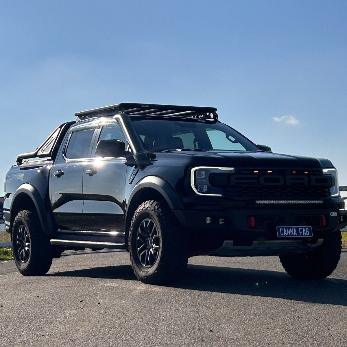 Black Ford Next-Gen Ranger Raptor with roof platform and Canna Fabrication stainless snorkel — front three-quarter view